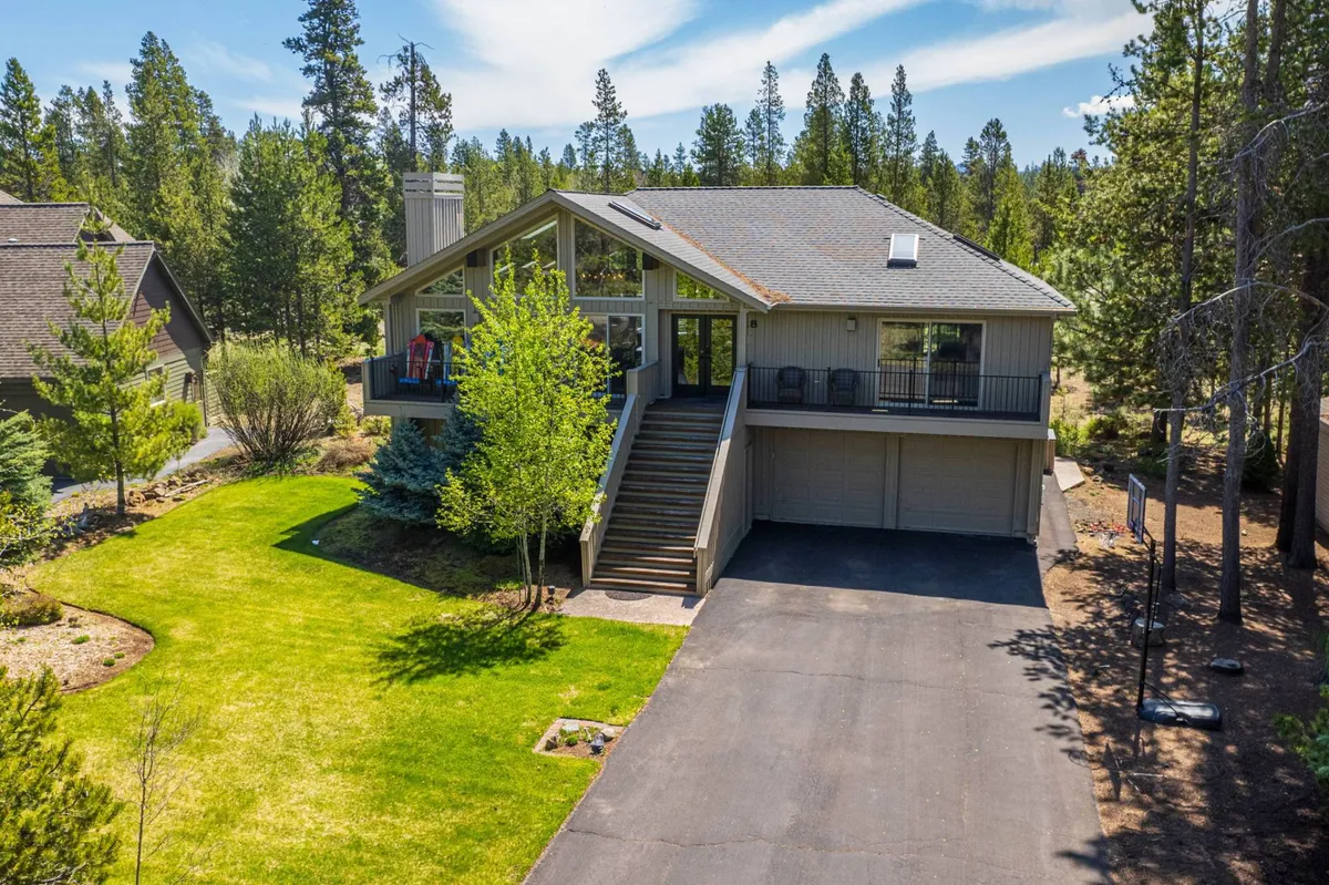 A broad exterior shot capturing the home's welcoming front entrance, large windows, and lush surrounding greenery. The scene exudes an inviting, resort-like atmosphere that hints at the comfort awaiting guests after outdoor adventures.
