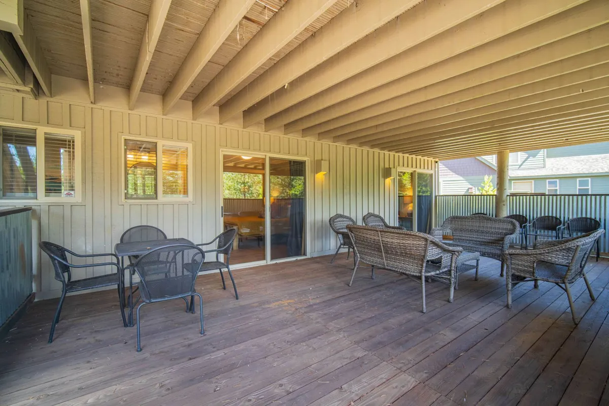 This image showcases a sunlit seating area with wicker chairs and a wooden floor, all positioned by large windows that let in abundant natural light. The space feels airy and inviting, suggesting a seamless transition between indoor comfort and the outdoors. The sense of openness and the visible connection to the exterior environment evoke relaxation and leisure.